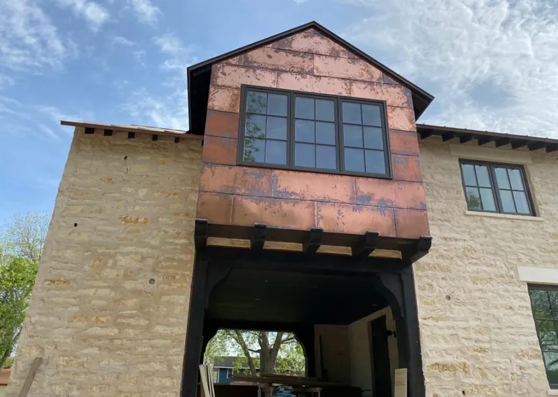 Copper metal panel facade on a stone building for Skylight Installation in College