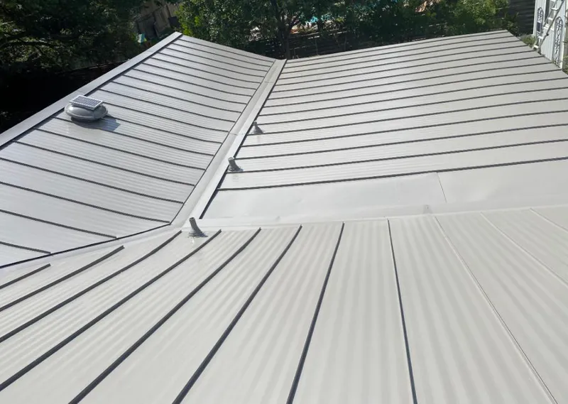 Solar attic fan installed on a metal roof for Roof Ventilation in College